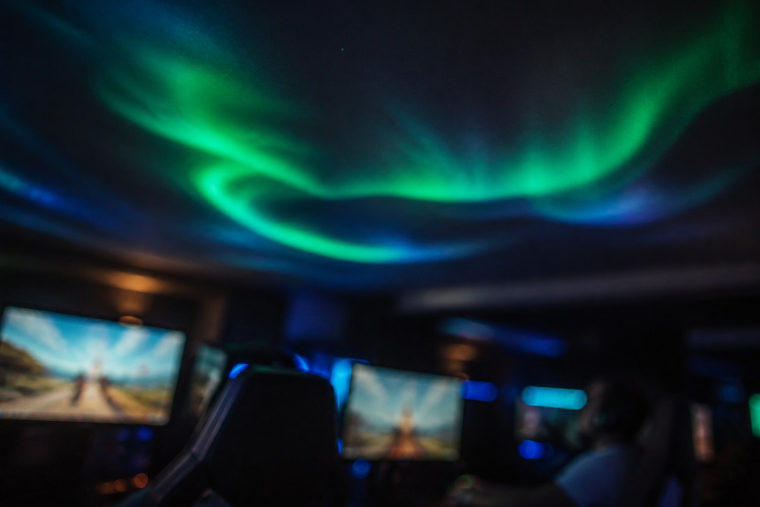 Wide view of the gaming hall with a dark upper wall carrying a ribbon of aurora light